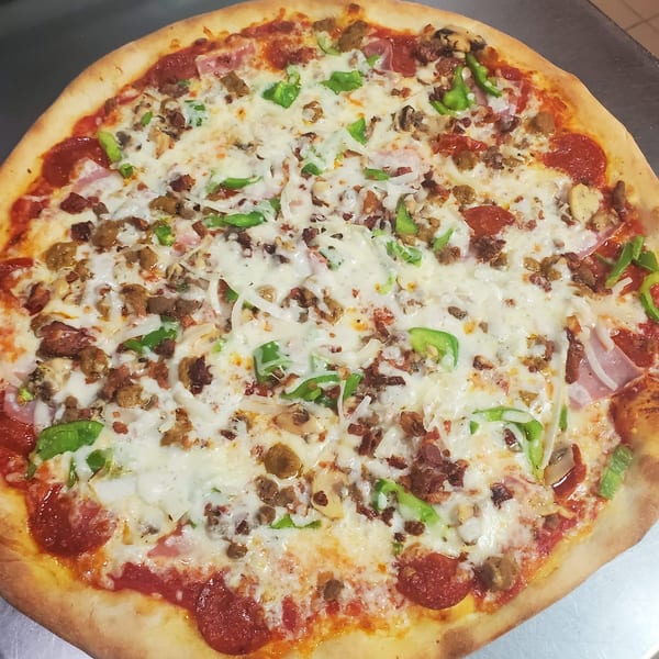 A large, freshly baked La Bella Italia pizza with pepperoni, sausage, green peppers, and onions.