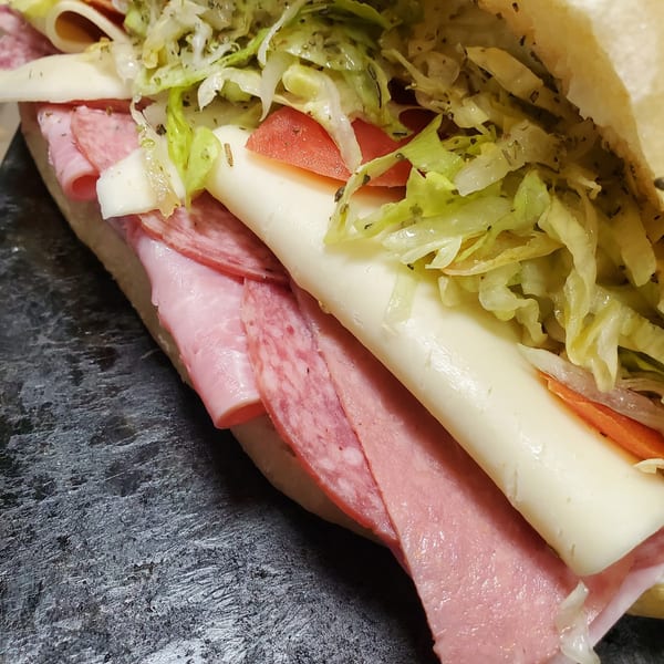 Close-up of a La Bella Italia Italian sub sandwich with salami, ham, cheese, lettuce, and tomatoes.
